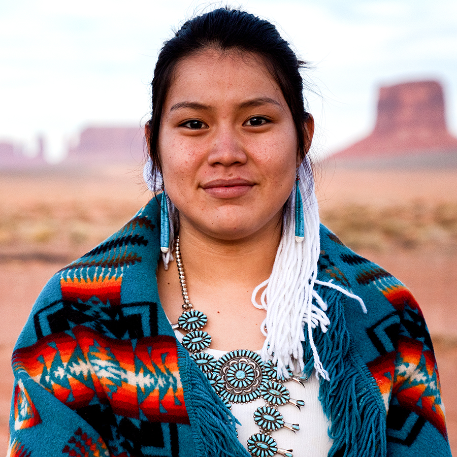 Native American woman on Tribal land stands outside.