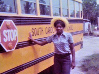 Joyce standing next to the bus that she drove in high school